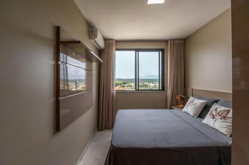 Un dormitorio con una cama y una ventana grande. en Vista Baía do Pontal • Piscina • Ao Lado Gbarbosa, en Pontal de São João da Barra