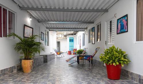 a hallway with a table and chairs and plants at BALLESTRINQUE - GETSEMANI- CARTAGENA DIVINa in Cartagena de Indias