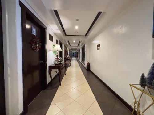 Un pasillo con una puerta y suelo de baldosas. en D' Leonor Hotel, en Davao City