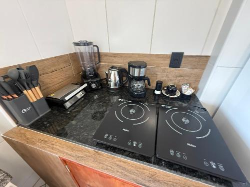 eine Küche mit einem Herd und einem Mixer auf der Theke in der Unterkunft Apartamento no Centro de Sorocaba com vaga de garagem in Sorocaba