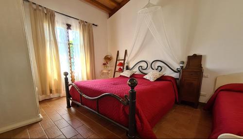 een slaapkamer met een rood bed en een raam bij Appartamento Papavero Seaside and Pool in La Caduta