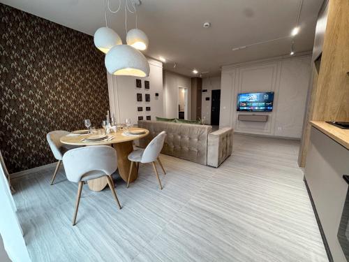 Un comedor con una mesa y sillas y un sofá. en Airport dream - Modern, King size beds, en Someşeni