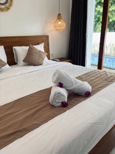 a towel animal is laying on a bed at Amitha Lodge Uluwatu in Uluwatu