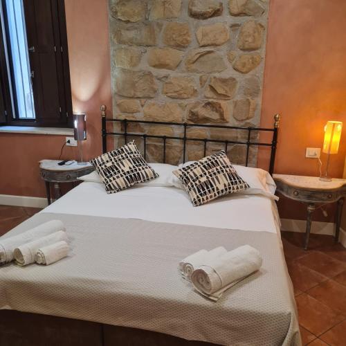 a bedroom with a bed with towels and a stone wall at Eden House in Crotone