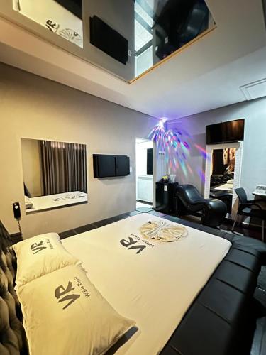 Schlafzimmer mit einem großen Bett und schwarzen Möbeln in der Unterkunft Motel Vitoria Reggia in São Vicente