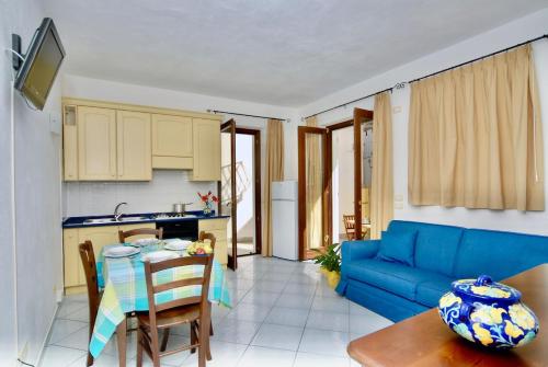 Una cocina y una sala de estar con un sofá azul. en Maloon apt - 450m from the beach, en Isquia