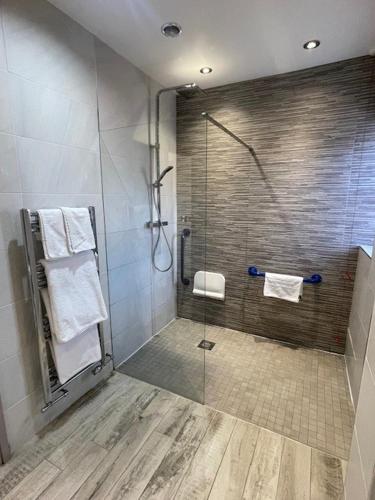 a bathroom with a shower with a glass door at Cock O' Barton in Coddington