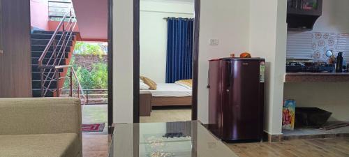 een woonkamer met een kleine koelkast in een kamer bij Mountain Breeze 2BHK with a spectacular view in Bhowāli