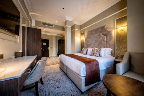 a hotel room with a bed and a desk at Walled City Hotel in Derry Londonderry