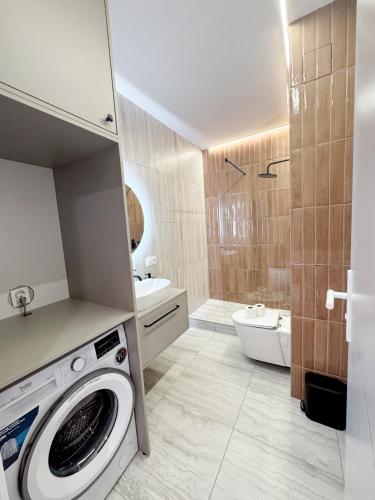 a bathroom with a washer and a washing machine at Sky Escape - Private Parking, Kingsize Bed & More in Cluj-Napoca