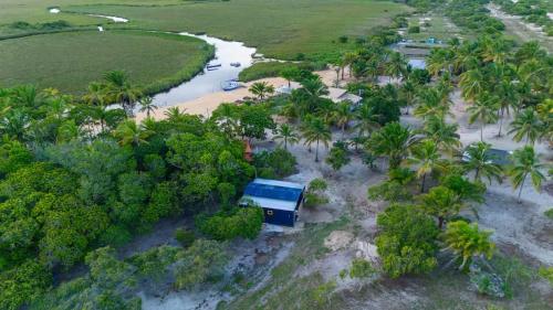 una vista aerea di una casa su una spiaggia con palme di Container Azul na beira do rio e a poucos metros do mar a Belmonte