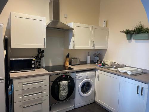 a kitchen with a washer and a washing machine at Number 10 service apartment - Danes in Southampton