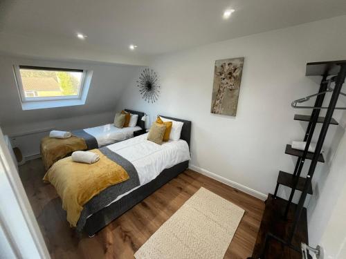 Woodfield Cottage Crawley 3 BR,Parking,Wifi,Garden, nearby Gatwick Airport, Contractor friendly, temporary relocations, business travellers, families في كراولي: غرفة نوم بها سريرين ونافذة