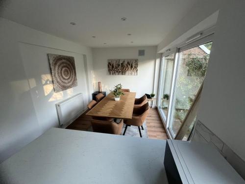 Woodfield Cottage Crawley 3 BR,Parking,Wifi,Garden, nearby Gatwick Airport, Contractor friendly, temporary relocations, business travellers, families في كراولي: غرفة طعام مع طاولة وكراسي ونافذة