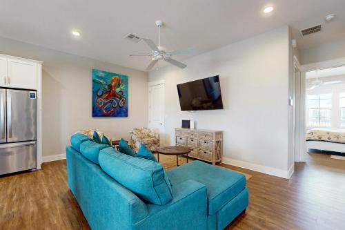 ein Wohnzimmer mit einer blauen Couch und einer Küche in der Unterkunft The Wild Octopus at Palmilla Beach in Port Aransas