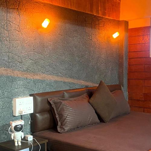 a couch in a room with two lights on the wall at Anemoi Chimes Resort Calvarymount in Idukki