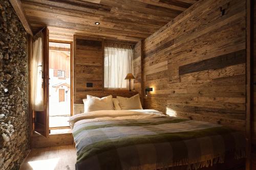 una camera da letto con un letto con una parete in legno di Alpine Woodhouse a Valtournenche