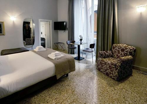 een hotelkamer met een bed en een stoel bij Dimora Donna Elena in Napels