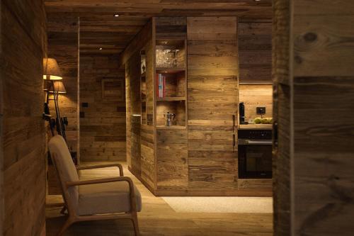 una cucina con pareti in legno, tavolo e sedia di Alpine Woodhouse a Valtournenche