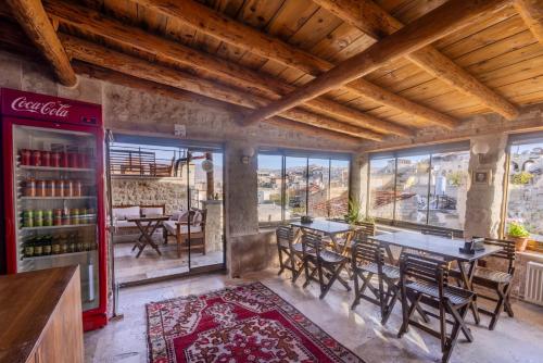 a restaurant with tables and chairs and a cocacola refrigerator at Zula Cave House in Ürgüp