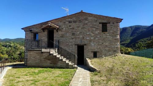 Agriturismo Al Vicinale في جينجا: مبنى حجري قديم فوق تلة