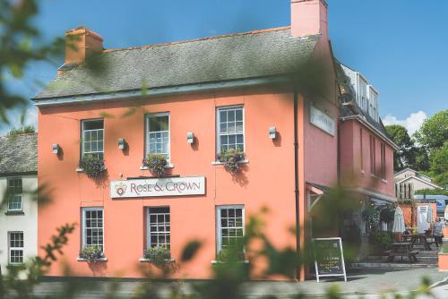 a orange building with a sign for a restaurant at Rose and Crown Yealmpton in Yealmpton