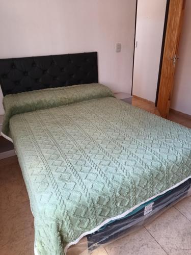 een slaapkamer met een bed met een groen dekbed bij El Parque in San Luis