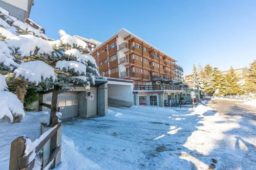 a snow covered street in front of a building at La Tana Dell'Ermellino 3 Ski In Ski Out - Happy Rentals in Sestriere