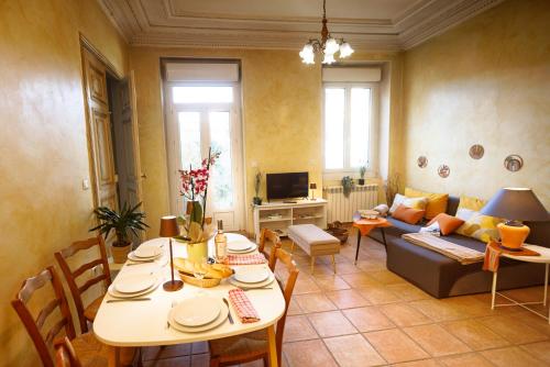 un soggiorno con un tavolo e un divano di L Ambrosien, un nid douillet a Saint-Ambroix