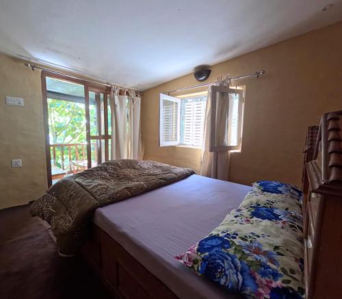 una cama en una habitación con ventana en Bulbul Farm Retreat, en Tānsing