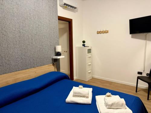 a bedroom with a blue bed and a tv at Dea Bendata HERMES in Palestrina