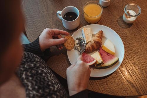 クリスティアンスンにあるQuality Hotel Grand Kristiansundの食べ物の皿を持ってテーブルに座っている人