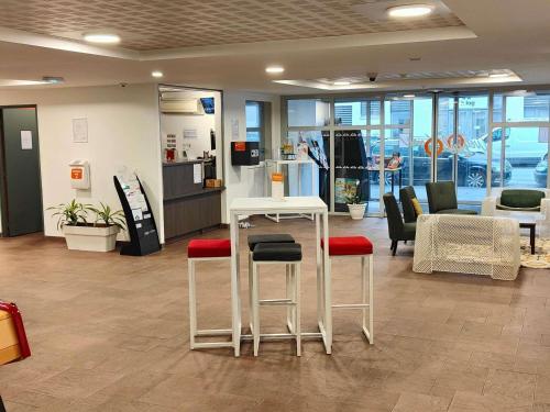 un vestíbulo con una mesa y sillas en una tienda en Aparthotel Adagio Access Poitiers, en Poitiers