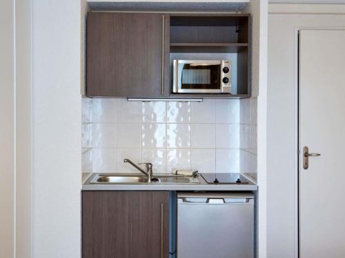ポワティエにあるアパートホテル アダージョ アクセス ポワティエのシンクと電子レンジ付きのキッチン