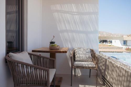 Un balcón con una mesa y sillas y una ventana. en Hotiday Mykonos South Coast, en Mykonos ciudad