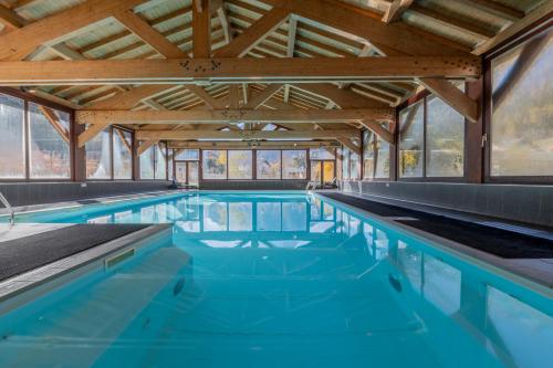 瓦洛西讷l'Ours Bleu B01 - Ski in Ski out - Happy Rentals的一座大型游泳池拥有木制天花板和蓝色的海水