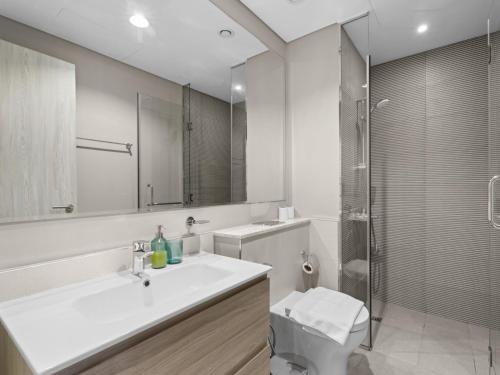 ein weißes Badezimmer mit Waschbecken und Dusche in der Unterkunft Zada Glam Sleek 1BDR Retreat-Business Bay-25 in Dubai