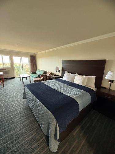 Una habitación de hotel con una cama y una sala de estar. en OceanShores Inn, en Ocean Shores