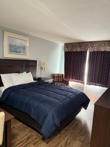 Un dormitorio con una cama grande con una manta azul. en OceanShores Inn, en Ocean Shores