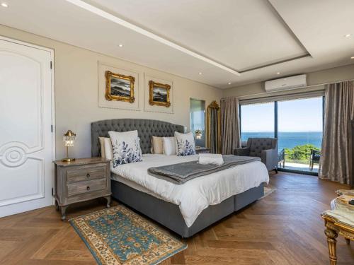 een slaapkamer met een bed met uitzicht op de oceaan bij Marang Villa in Kaapstad