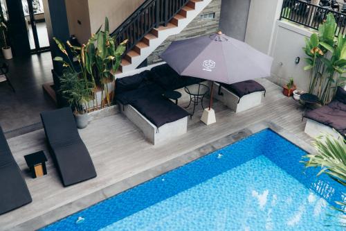 an overhead view of a swimming pool with an umbrella at Hi Cube Hostel in Canggu
