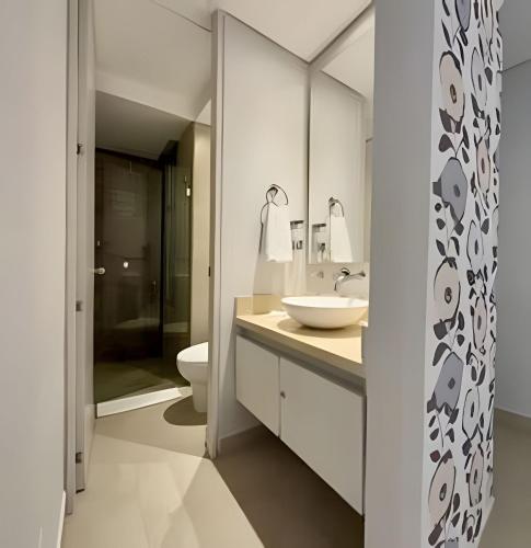 a white bathroom with a sink and a toilet at Suite moderna cerca del mar in Gaira