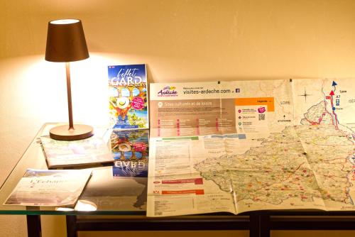 una mappa su un tavolo accanto a una lampada e una lampada di L Ambrosien, un nid douillet a Saint-Ambroix