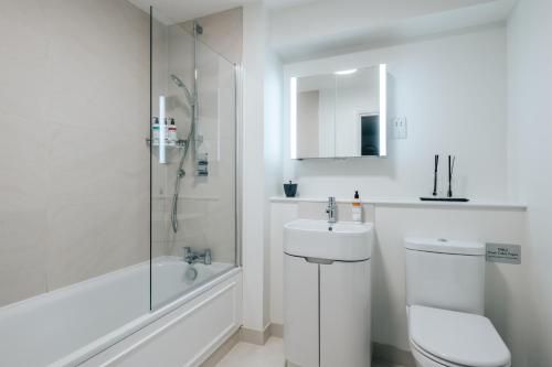 a bathroom with a toilet and a sink and a shower at The Eccleston by Nestor in London