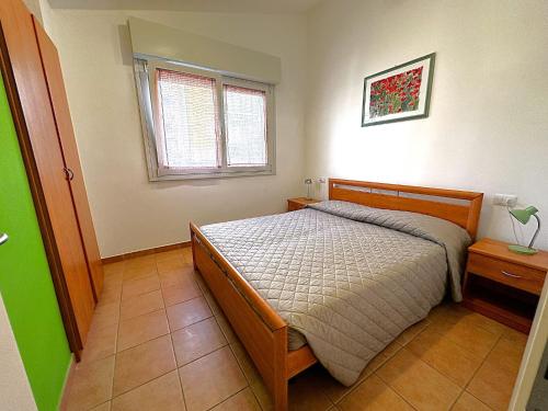 una camera da letto con un letto e una finestra di Comfy villa in central location a Bibione