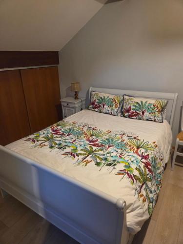 Una cama con un marco azul con una manta colorida encima. en Au Grés du Vent, en Ruy