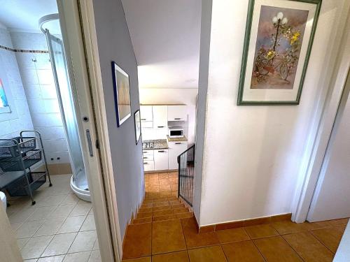 un corridoio che conduce a una cucina con un dipinto sul muro di Comfy villa in central location a Bibione