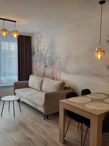 a living room with a couch and a table at Centrum Park Komfort in Kołobrzeg