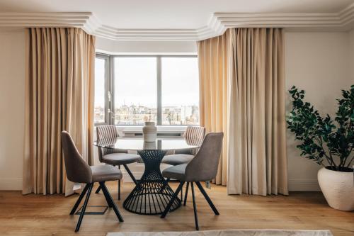 a dining room with a table and chairs and a large window at The Eccleston by Nestor in London