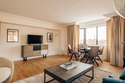 a living room with a television and a table at The Eccleston by Nestor in London